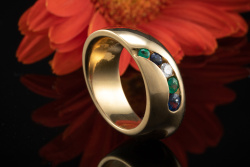 Schwungvolles Ring Design mit Saphir Smaragd und Brillant in Gelbgold